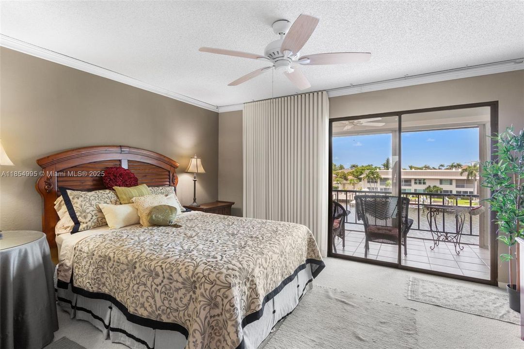 The SPACIOUS PRIMARY SUITE offers a WALK-IN CLOSET with custom cabinetry, a beautiful bathroom with stand-up shower, cabinetry, a makeup vanity, and access to your PRIVATE SCREENED BALCONY OVERLOOKING INTERSECTING CANAL!