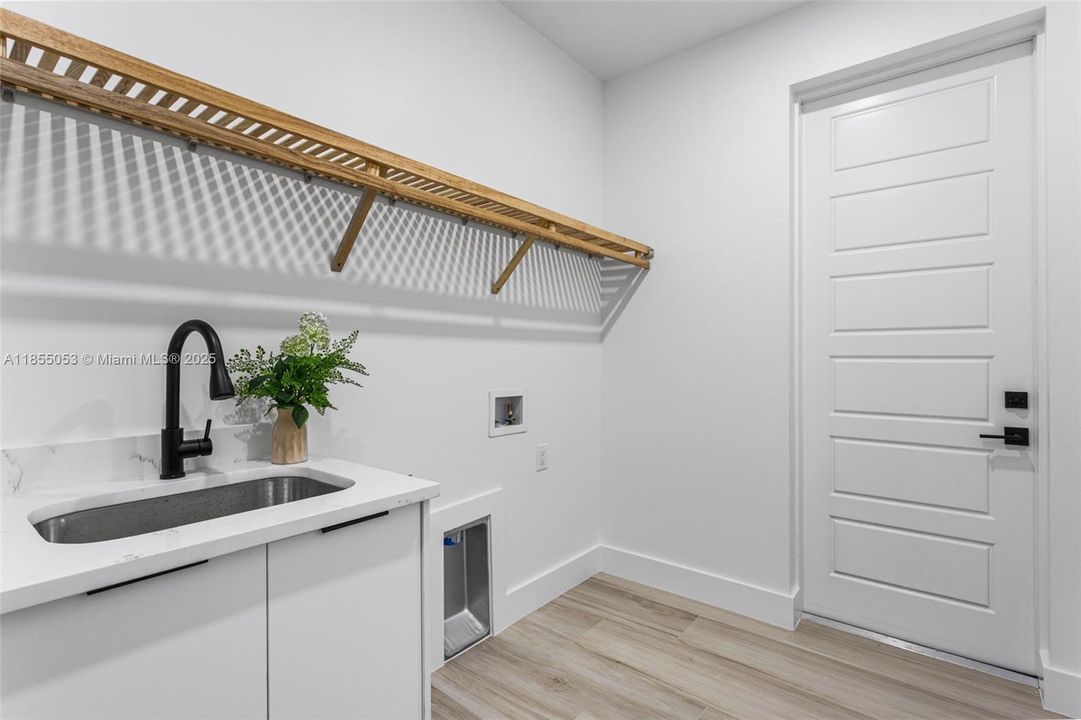 Laundry room is located as you walk into from garage & includes washer & dryer hook up & utility sink.