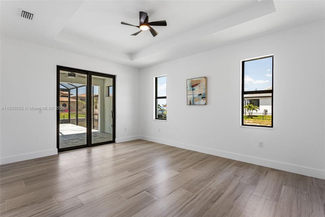 Primary suite offers plenty SPACE, including PRIVATE SLIDING DOORS TO LANAI & LARGE walk-in closets w/ wood shelving & hangers.