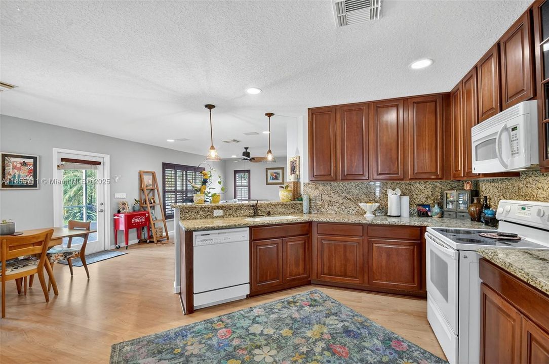 Open kitchen overlooks family room and breakfast area.