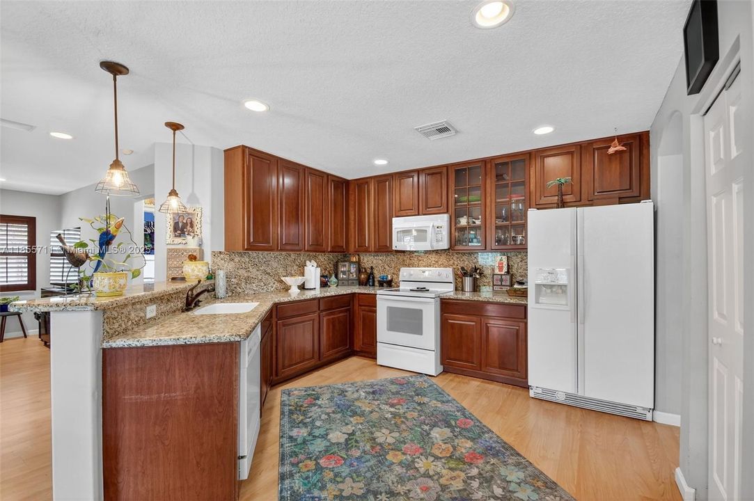 Open kitchen with snack bar and granite countertops.