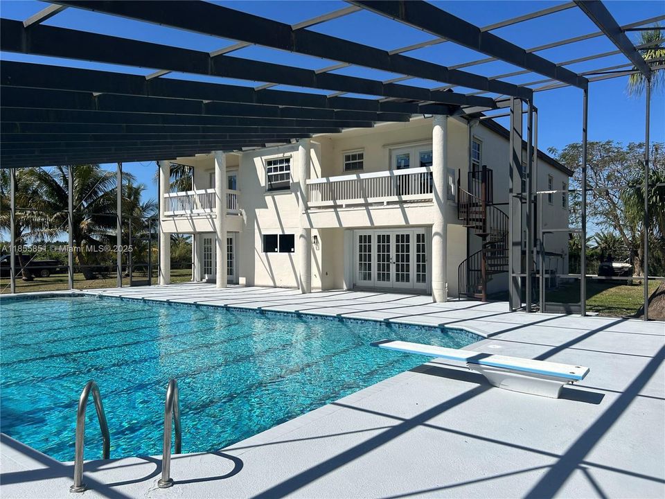 The private balcony overlooks the beautifully renovated oversized pool with waterfall, and the private and mature landscaping. Screen structure in place for any new owner who may desire a screened in patio.