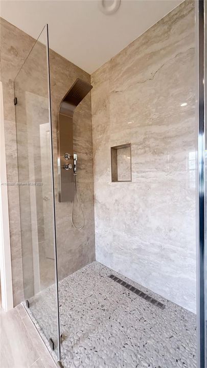 Start and end the day with luxurious custom master shower with glass wall and door.