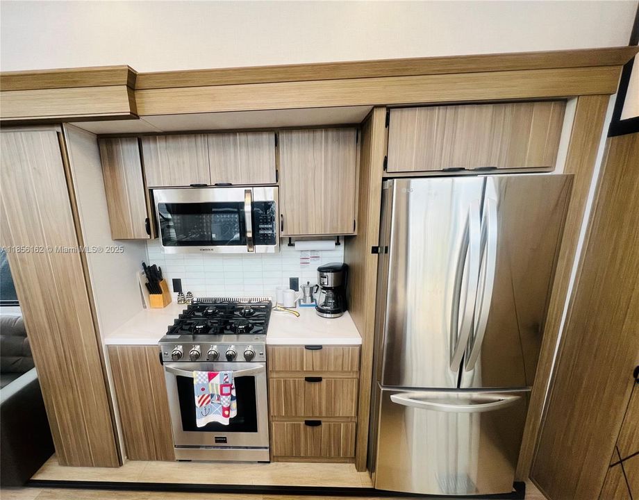 Residential Stainless Steel Appliances: Refrigerator w/Ice Maker, 4-Burner Gas Range, Full-Size Gas Oven, Microwave.