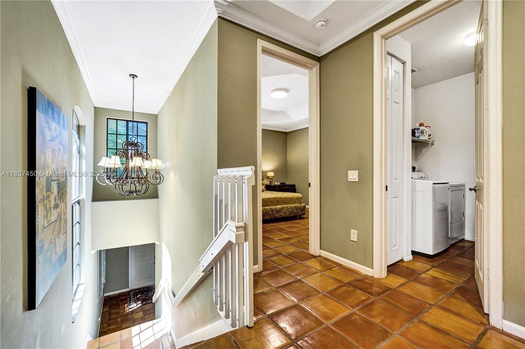 Top of stairs and looking into guest room and laundry room