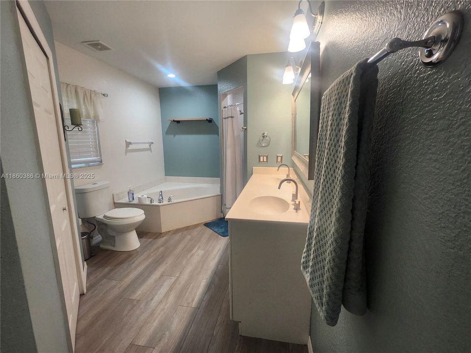 Spacious primary bathroom with Roman style tub, walk-in shower and double vanities.