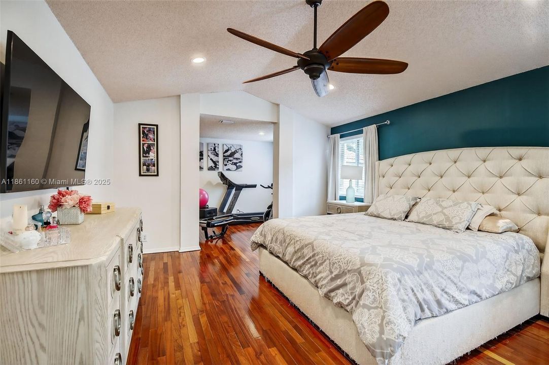 Unwind in the expansive primary bedroom suite, offering a generous layout and stylish modern finishes. Gleaming hardwood floors flow from the main sleeping area—large enough for a king-sized bed—into a connected bonus space ideal for a nursery, reading nook, or fitness area. This is more than just a bedroom; it's a personal haven.