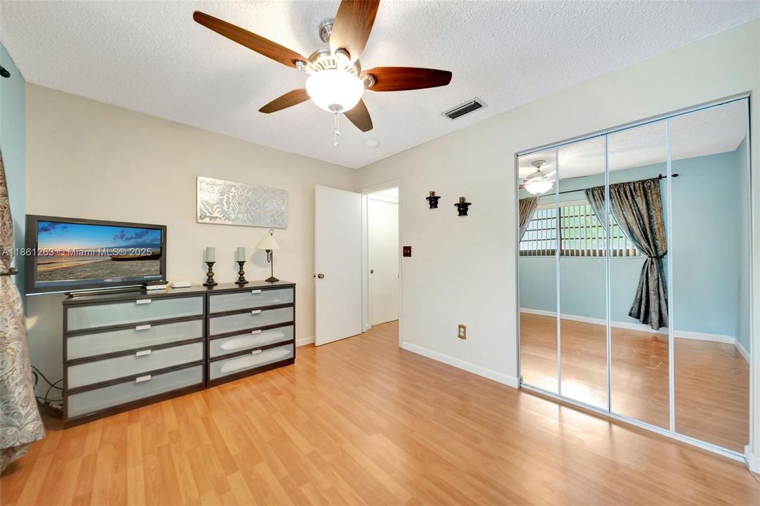 Stylish closet with mirrored doors and classic wooden flooring that enhances the space.