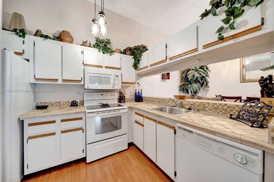 Beautiful kitchen with a breakfast bar, modern lighting, and views of the living and dining areas.
