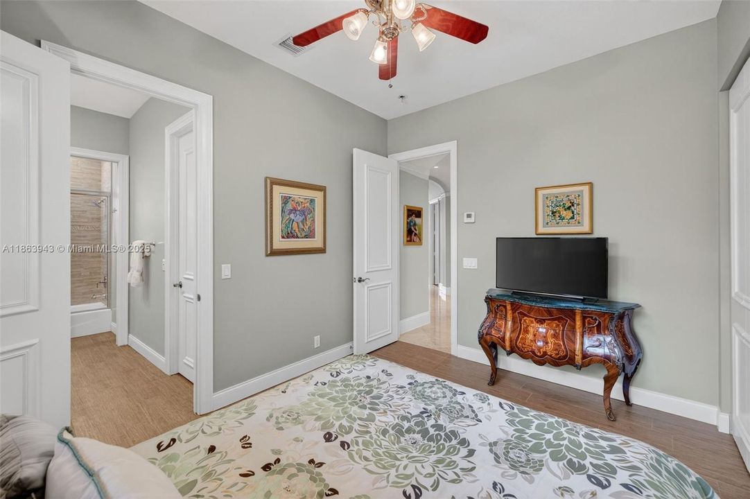 Guest bedroom w/ shared bathroom, also has a wall to wall closet and overlooks the side. yard of the house / fountain. Porcelain wood look flooring.