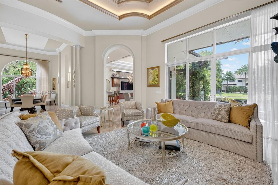 Expansive living area with coffered ceilings, crown molding, and designer details throughout.