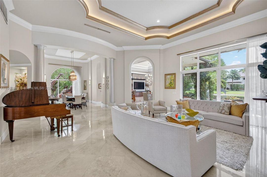 Expansive living area with coffered ceilings, crown molding, and designer details throughout.