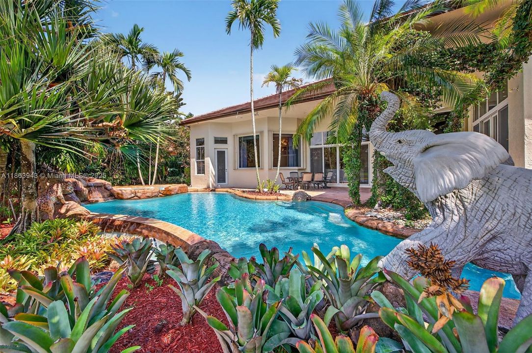 Tiki bar with Lynx grill, lush landscaping, and water features complete your backyard oasis.