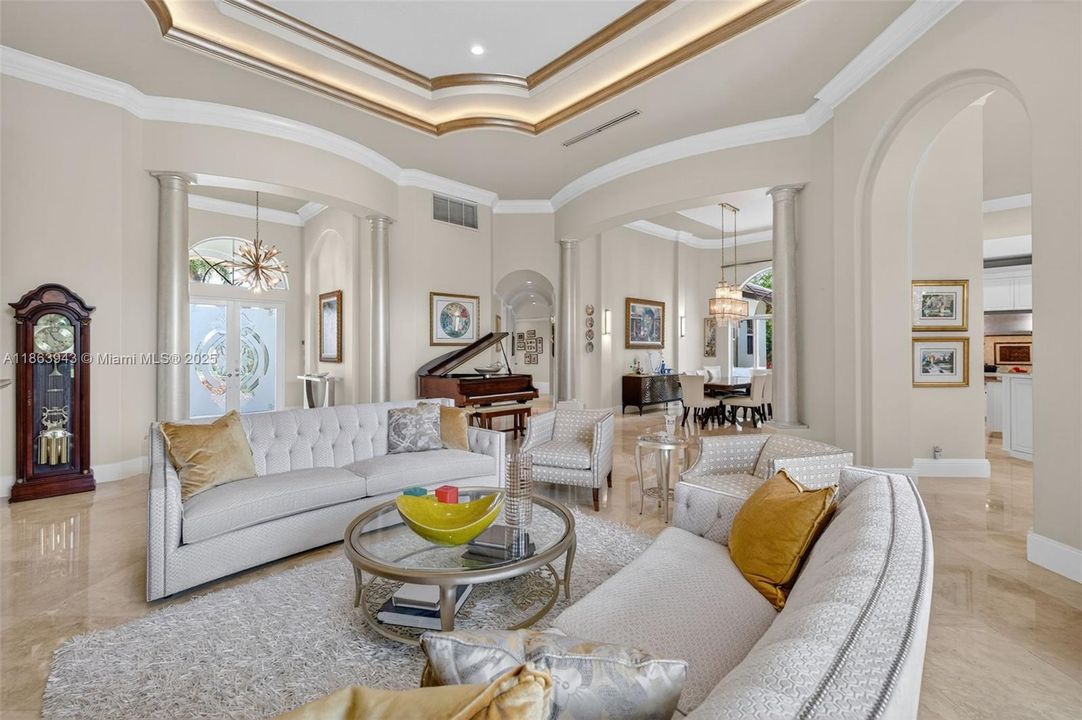 Expansive living area with coffered ceilings, crown molding, and designer details throughout.