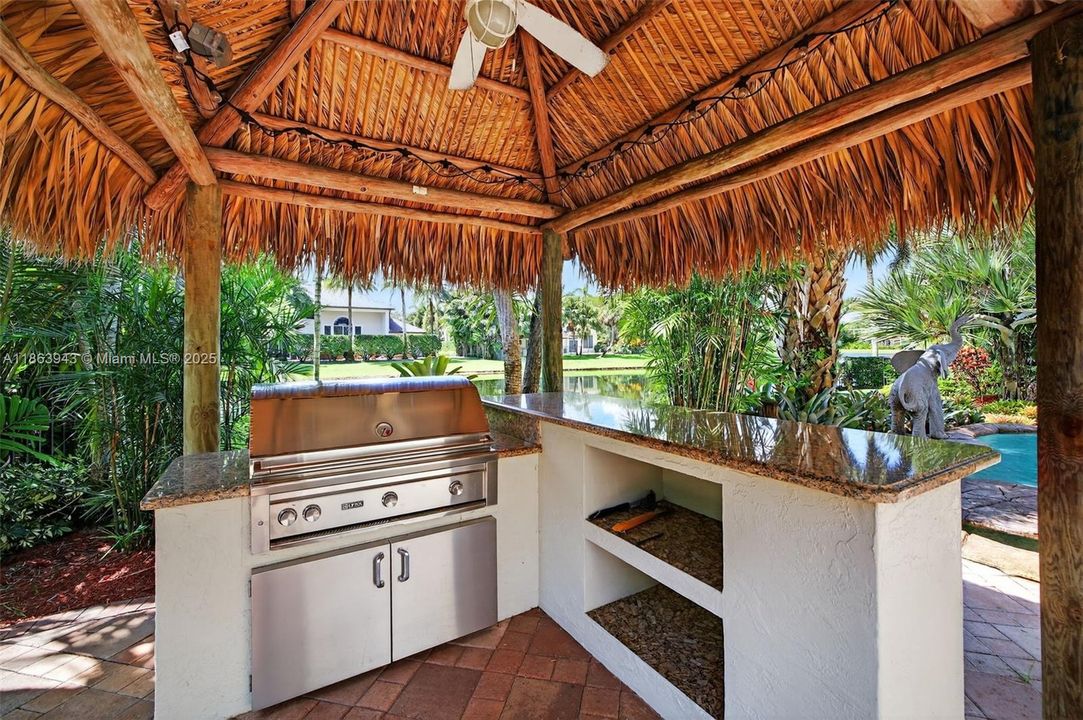 Tiki bar with Lynx grill, lush landscaping, and water features complete your backyard oasis.