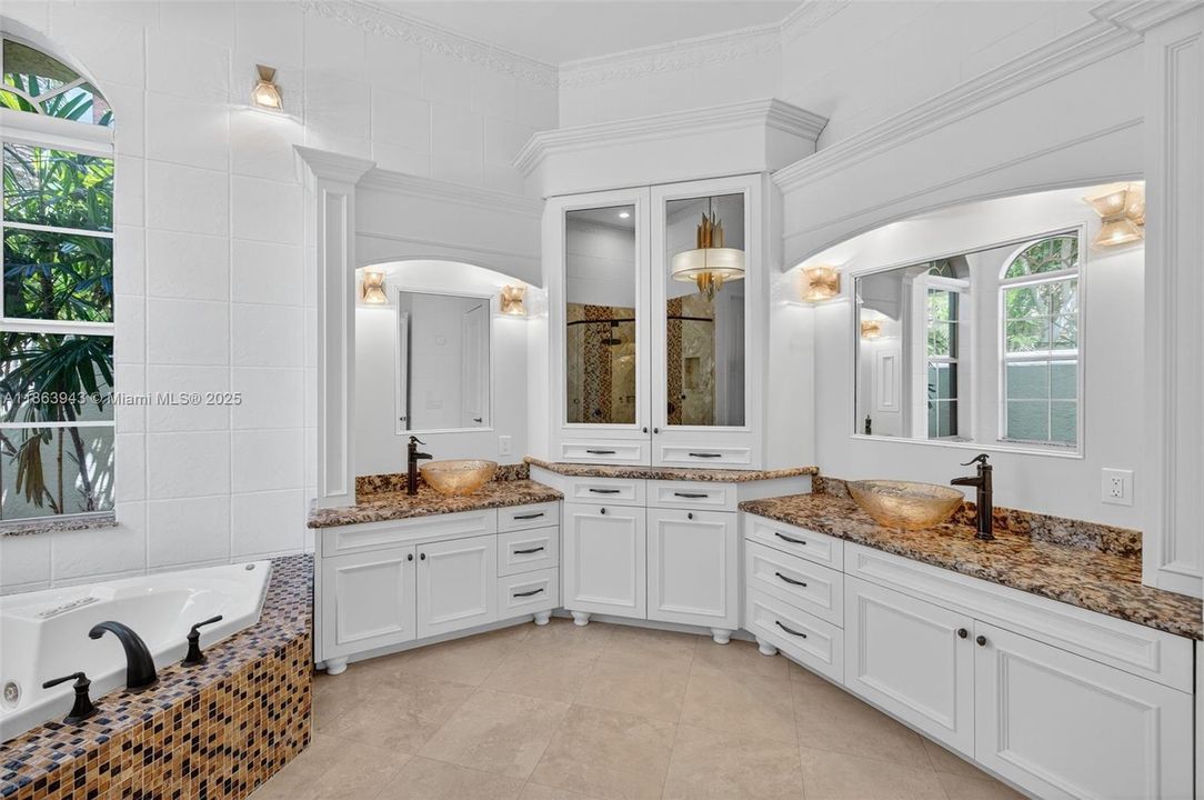 legant primary bath featuring rain shower, body jets, and dual vanities.