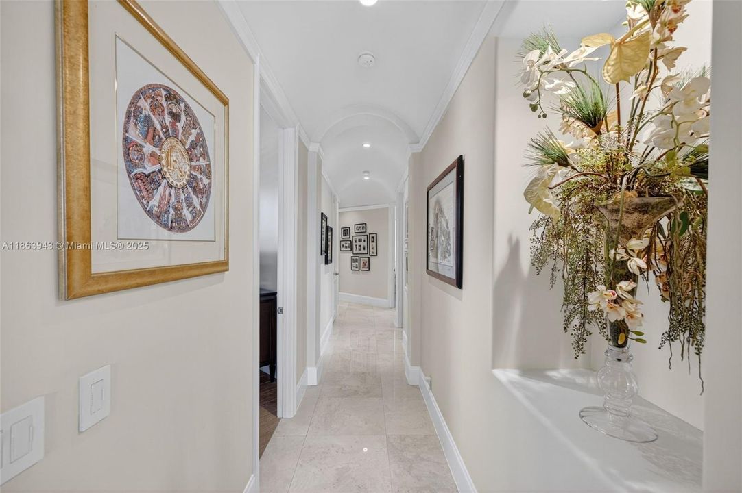 Beautiful hallway with arched ceiling architecture separates the wing of guest bedrooms from the main living space