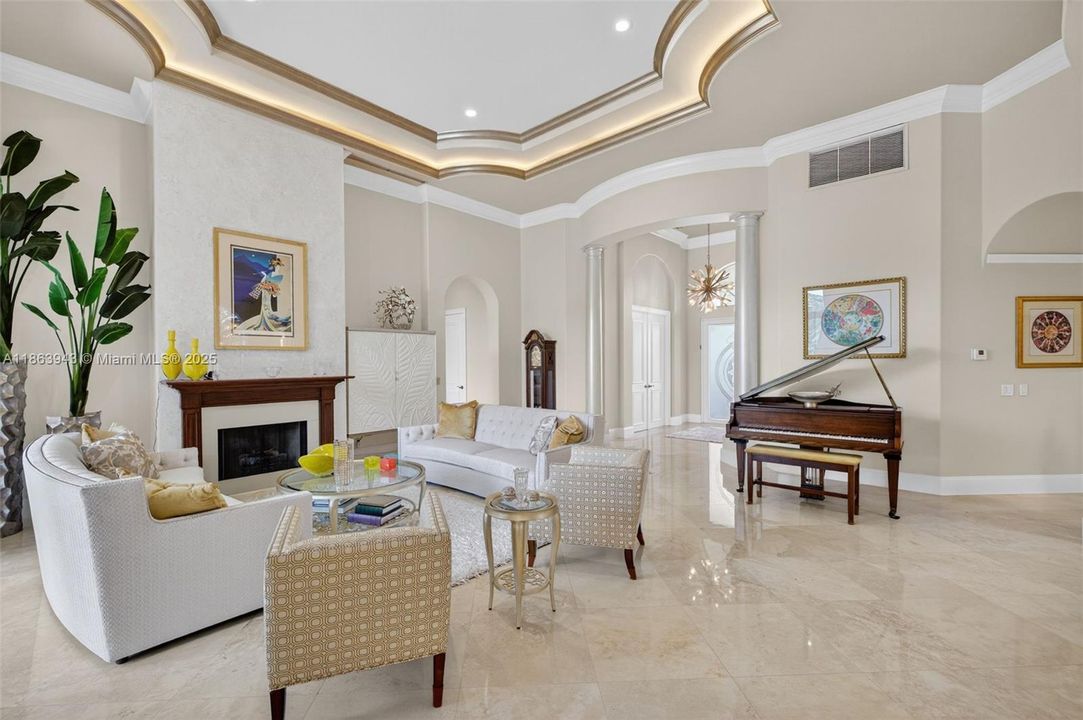Expansive living area with coffered ceilings, crown molding, and designer details throughout.