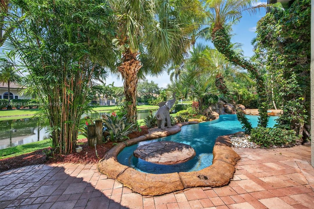 Tiki bar with Lynx grill, lush landscaping, and water features complete your backyard oasis.