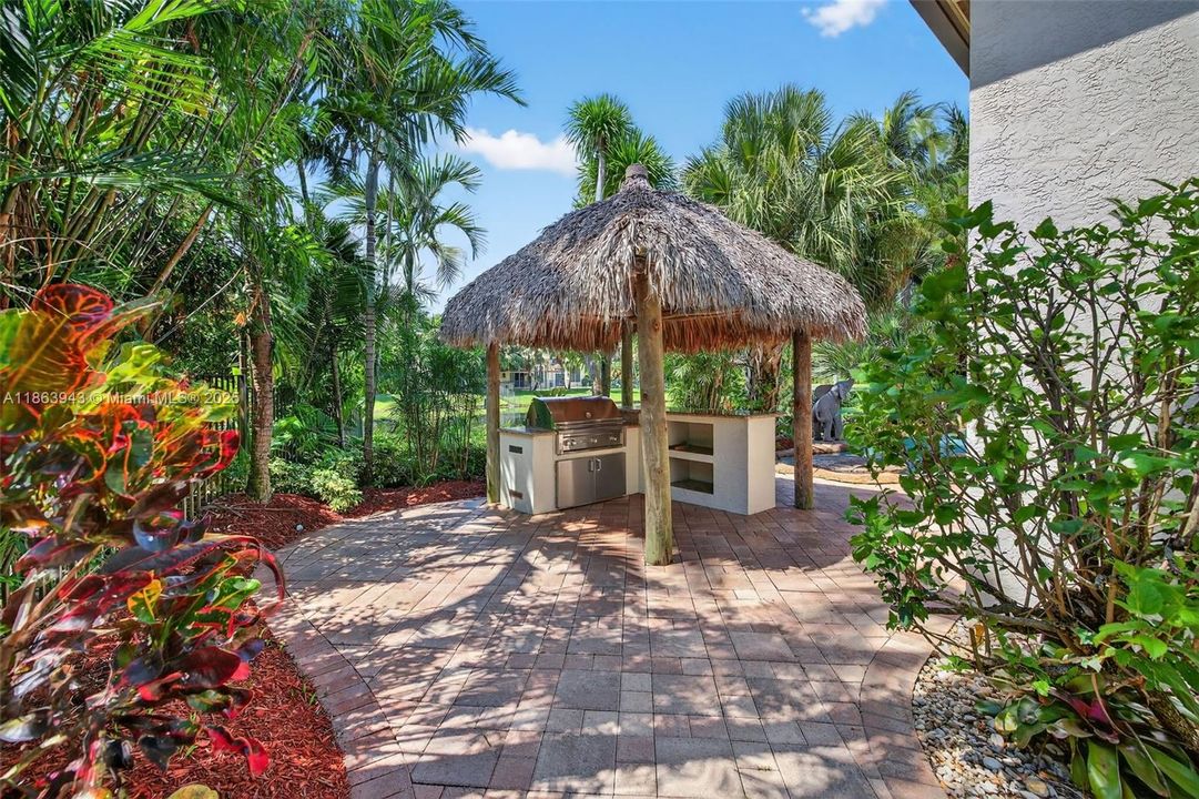 Tiki bar with Lynx grill, lush landscaping, and water features complete your backyard oasis.
