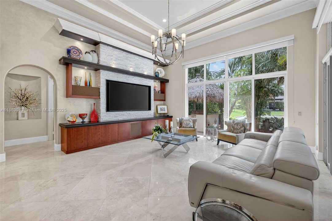 Expansive living area with coffered ceilings, crown molding, and designer details throughout.