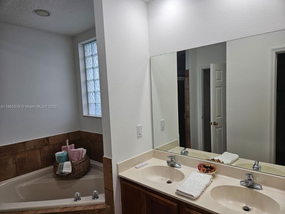 Master bath dual sinks, oversized tub, walk-in shower, and private toilet