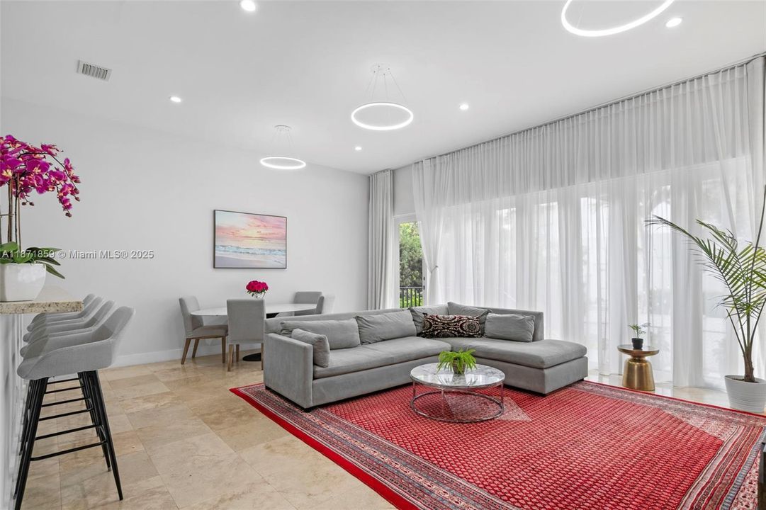 Bright open living area/w 11-ft ceilings & floor-to-ceiling windows & entrance to Private Back Yard.