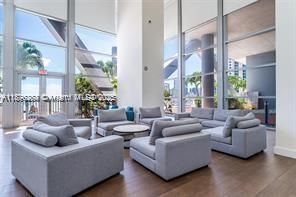 Elegant common lounge featuring contemporary décor and expansive glass walls that bring in natural light and water views.