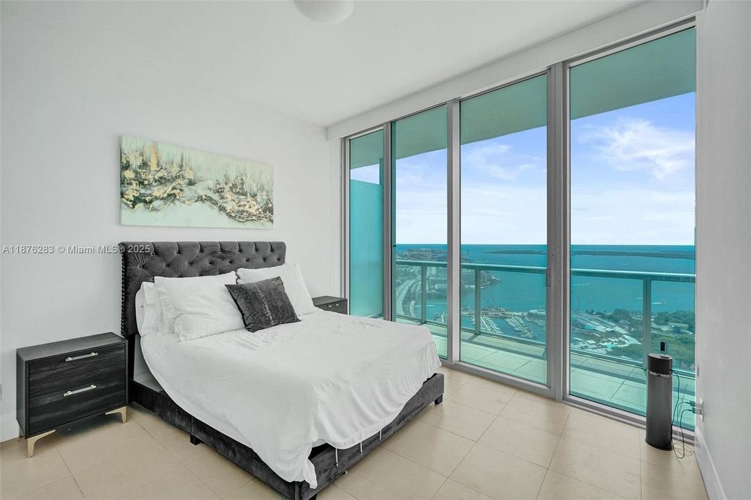 Generously sized bedroom with breathtaking bay and city views — wake up to the sunrise over Biscayne Bay.