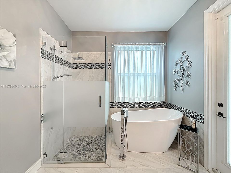 Remodeled with spacious walk in shower and separate stand alone tub. Door leads to outside patio