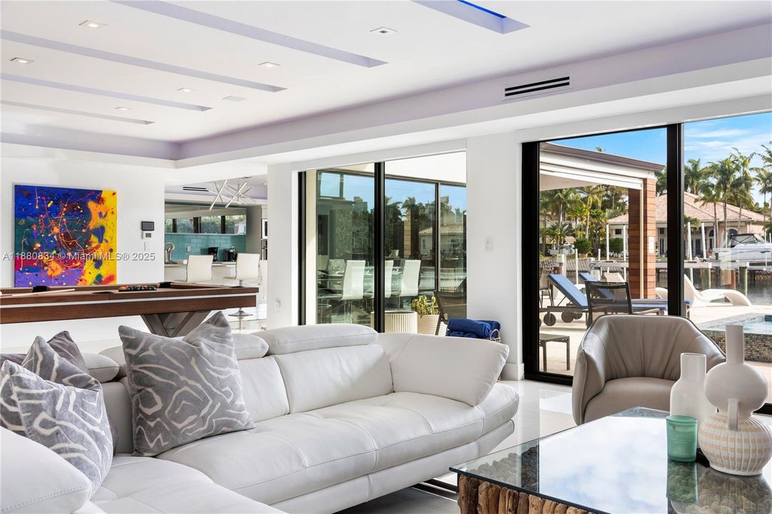 Contemporary living room with vibrant abstract art and water views.