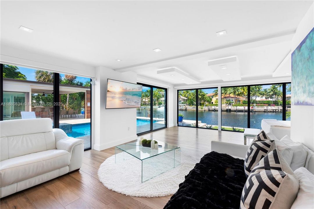 Second living area with a curved sofa and waterfront view.