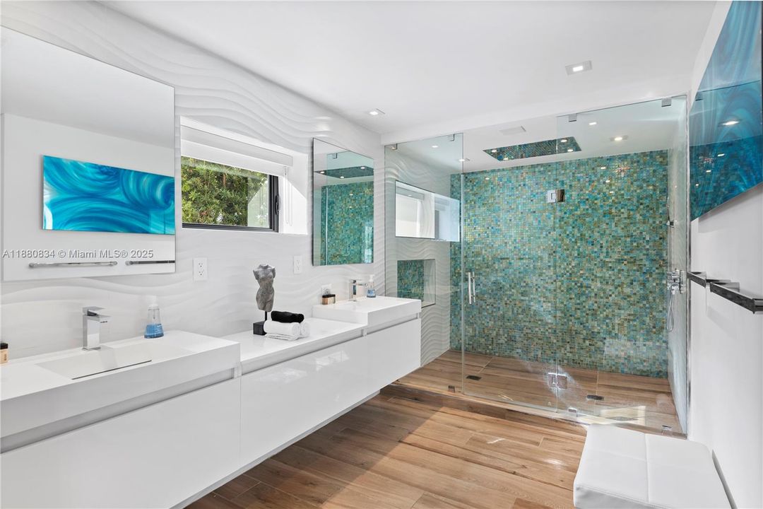 Sleek bathroom with a long double vanity and teal mosaic wall.