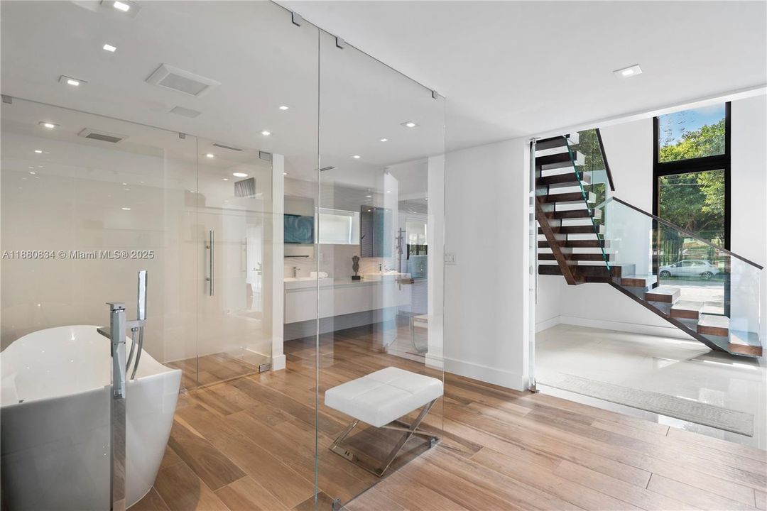 Modern bathroom with a freestanding tub and glass enclosure.