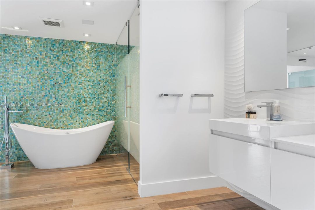 Clean white bathroom with tub and modern fixtures.