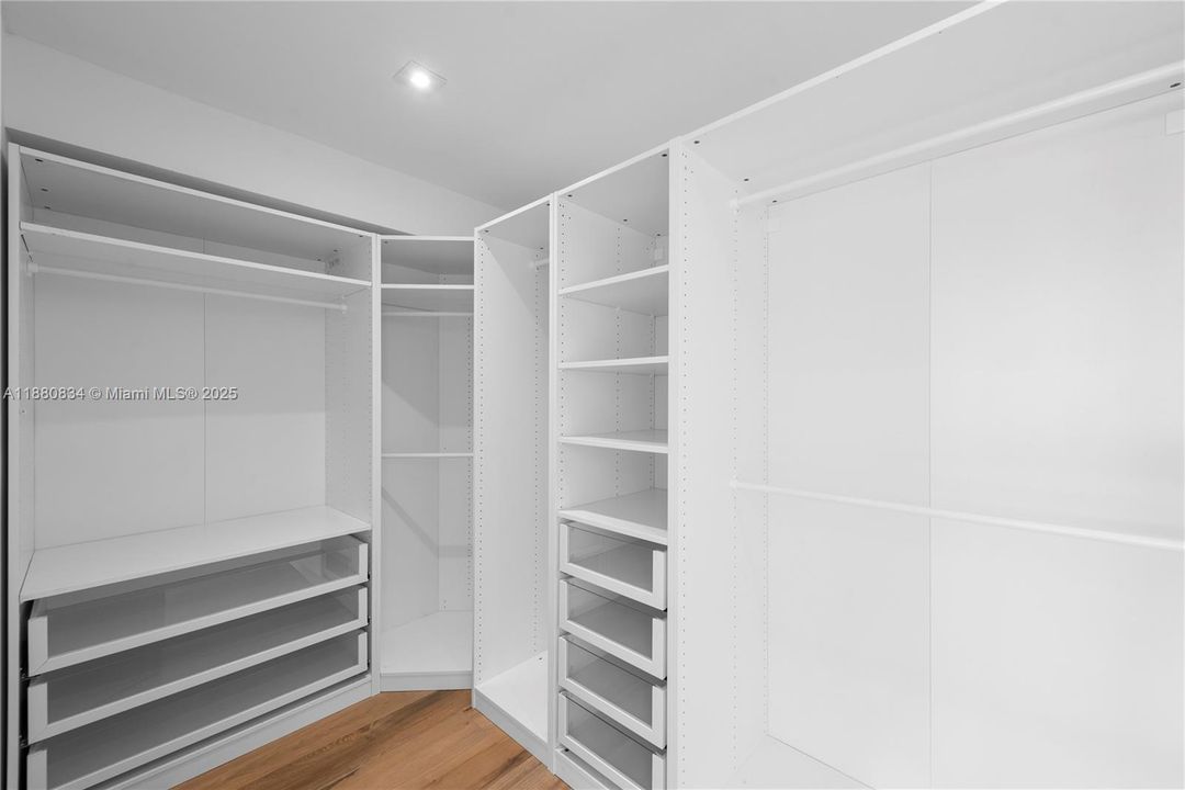 Spacious all-white walk-in closet with custom shelving.