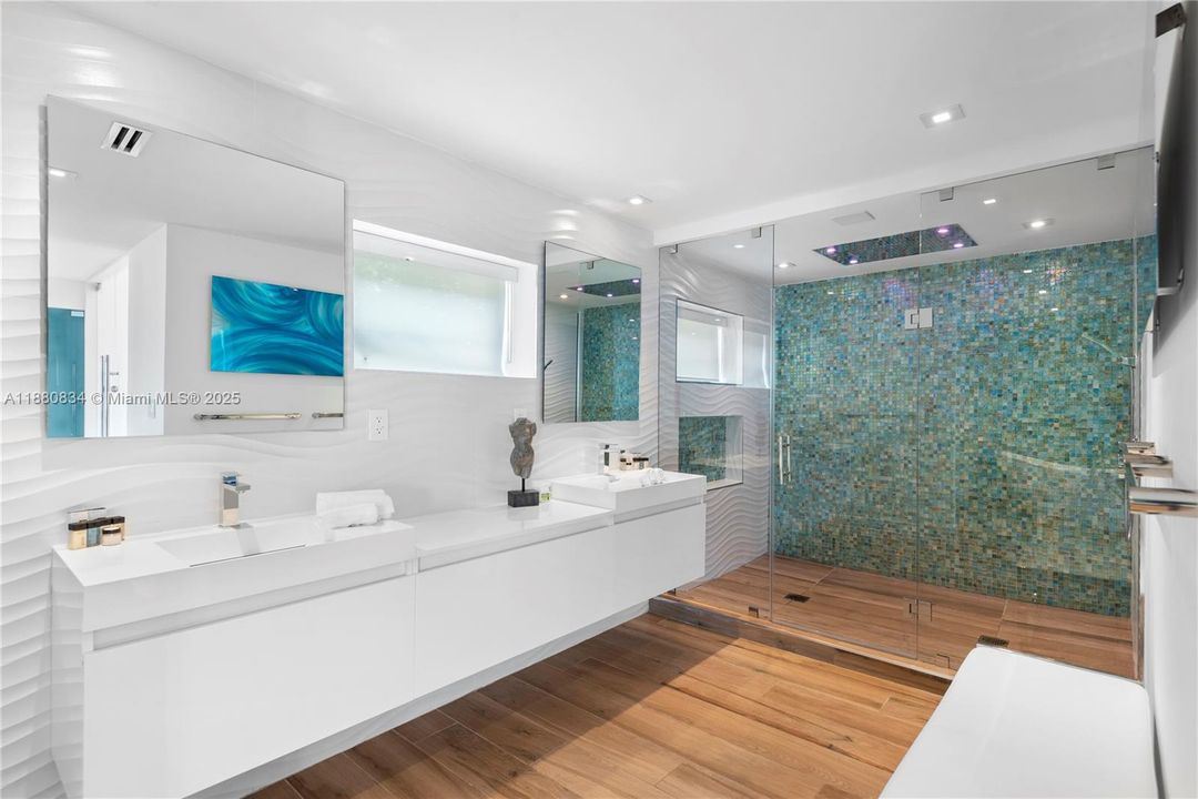 Modern bathroom with a double vanity and mosaic shower.