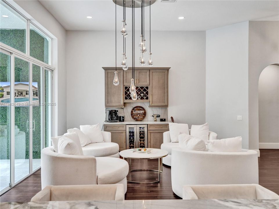 Beautiful dry bar off the living room, featuring quartzite countertops, double door wine fridge, ample cabinetry and counter space.?Enjoy as an espresso or drink mixing station.