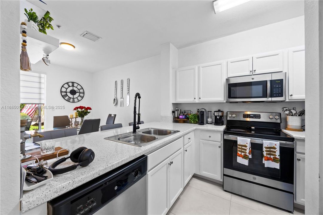 Kitchen with stainless steel appliances and quartz countertops.