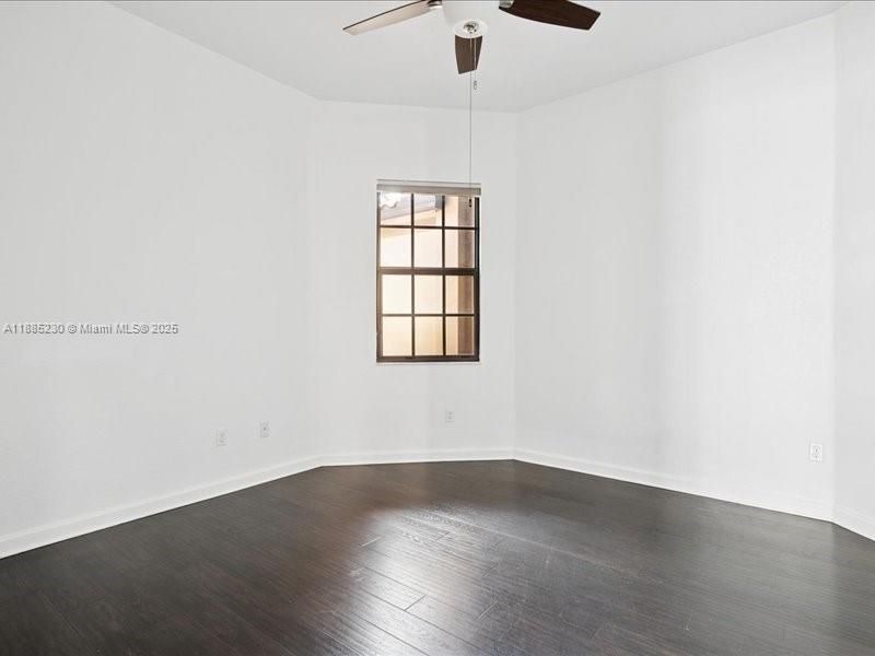 Refined third bedroom retreat with striking dark wood floors and a private split-plan location.