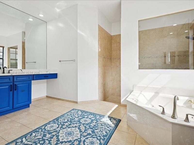 Grand owner’s bath designed for relaxation, offering double sinks, soaking tub, and oversized shower.