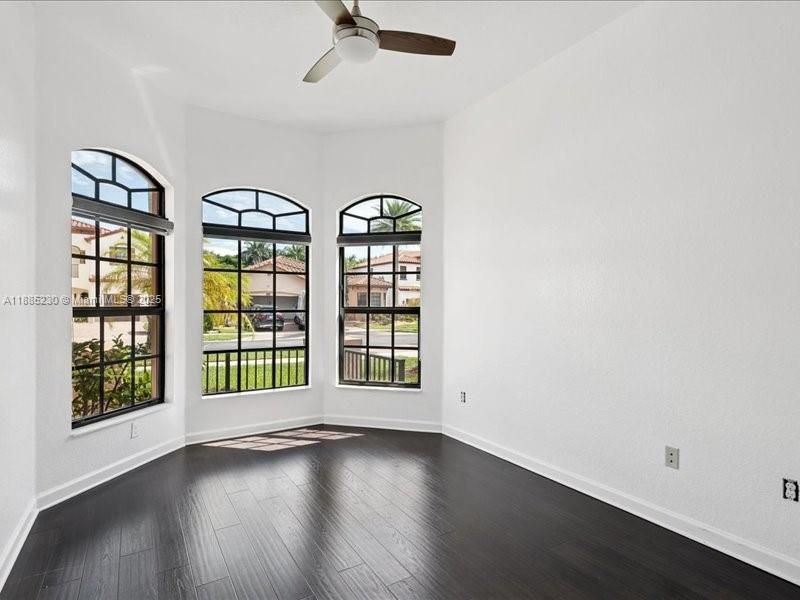 Versatile fourth bedroom or executive home office, accented by dark, rich wood flooring.