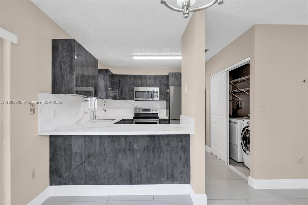 Modern kitchen with new stainless steel appliances, quartz counter tops, double sink and oversized pantry!