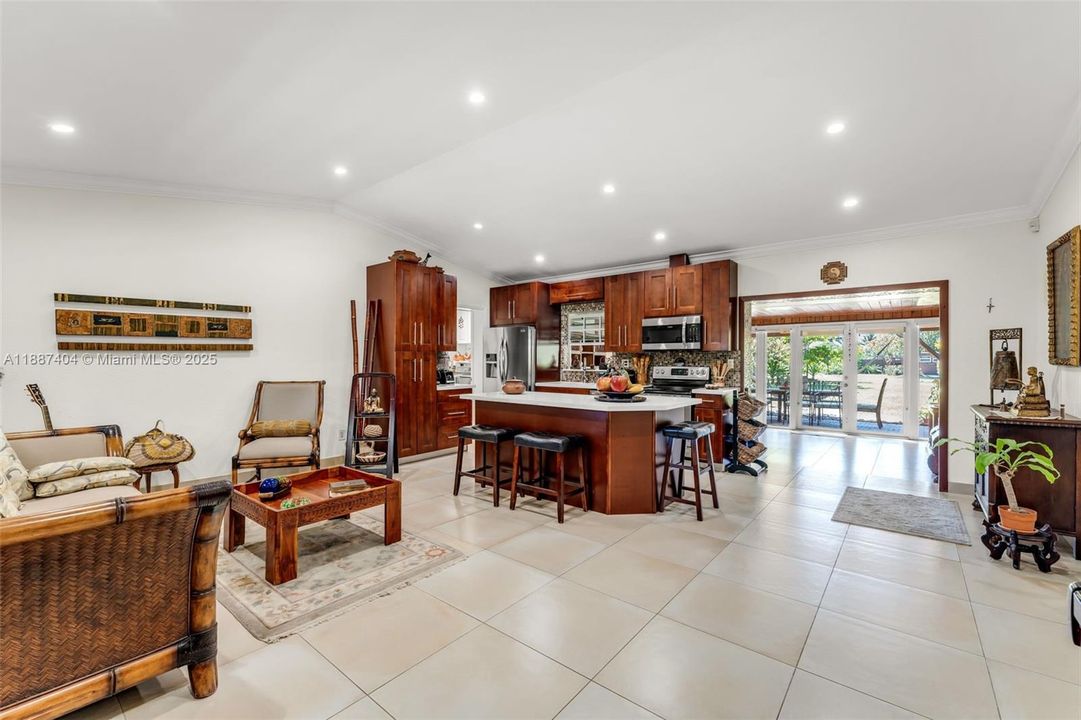 The living room, kitchen w/ custom cabinetry has vaulted ceilings. this space opens into the Florida room which opens to covered outside patio. a great organic space.