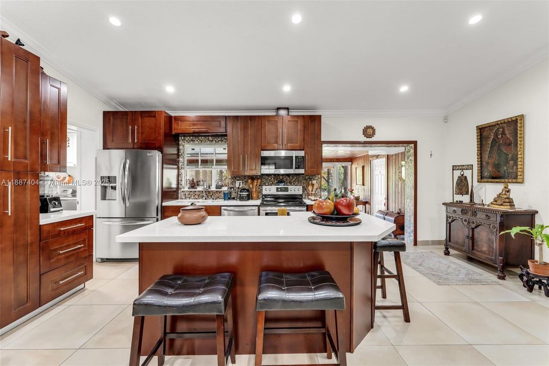 Beautiful kitchen overlooking living room w/ vaulted ceilings, oversized tile, sitting in the center of the 3 way split floorplan.