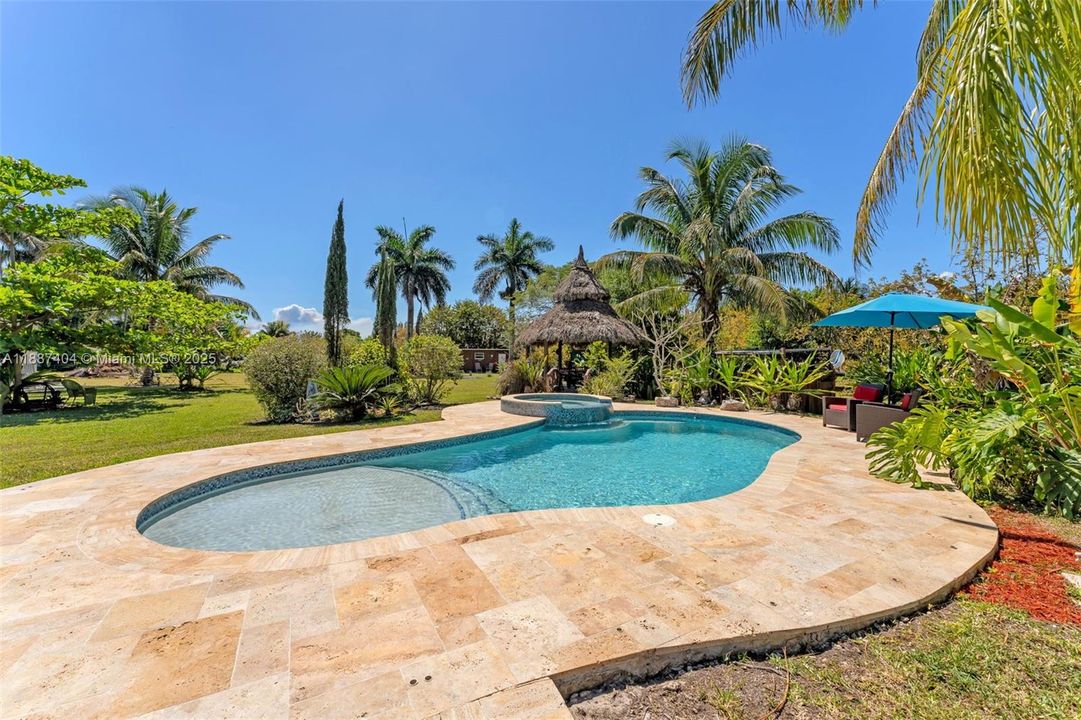 Custom pool w travertine, sand bar area, spa and tiki to enjoy lunch, drinks etc. while watching the swimmers. This is a great space with loads of privacy as the compound is wrapped in assorted fruit trees