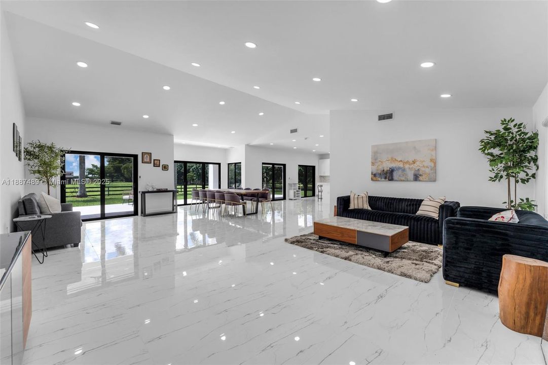 OPEN FLOOR PLAN W/ VAULTED CEILINGS, WITH A WALL OF INPACT WINDOWS OVERLOOKING THE REAR OF THE PROPERTY.