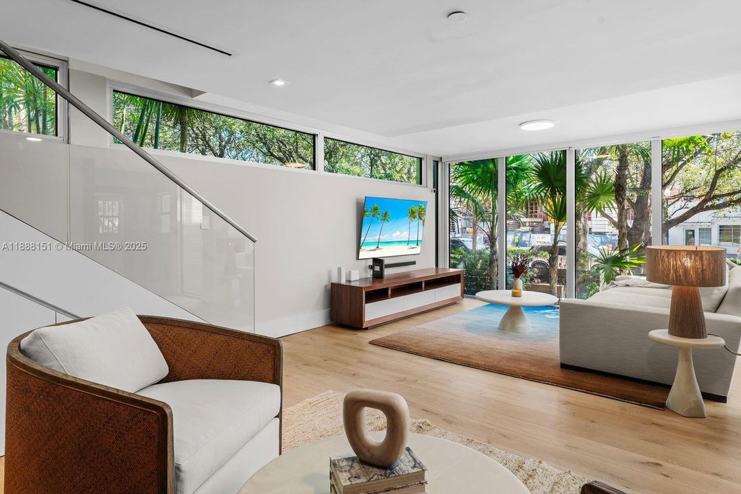 Cozy sitting space with large windows bringing in sunshine — Miami Beach indoor-outdoor lifestyle at its finest.