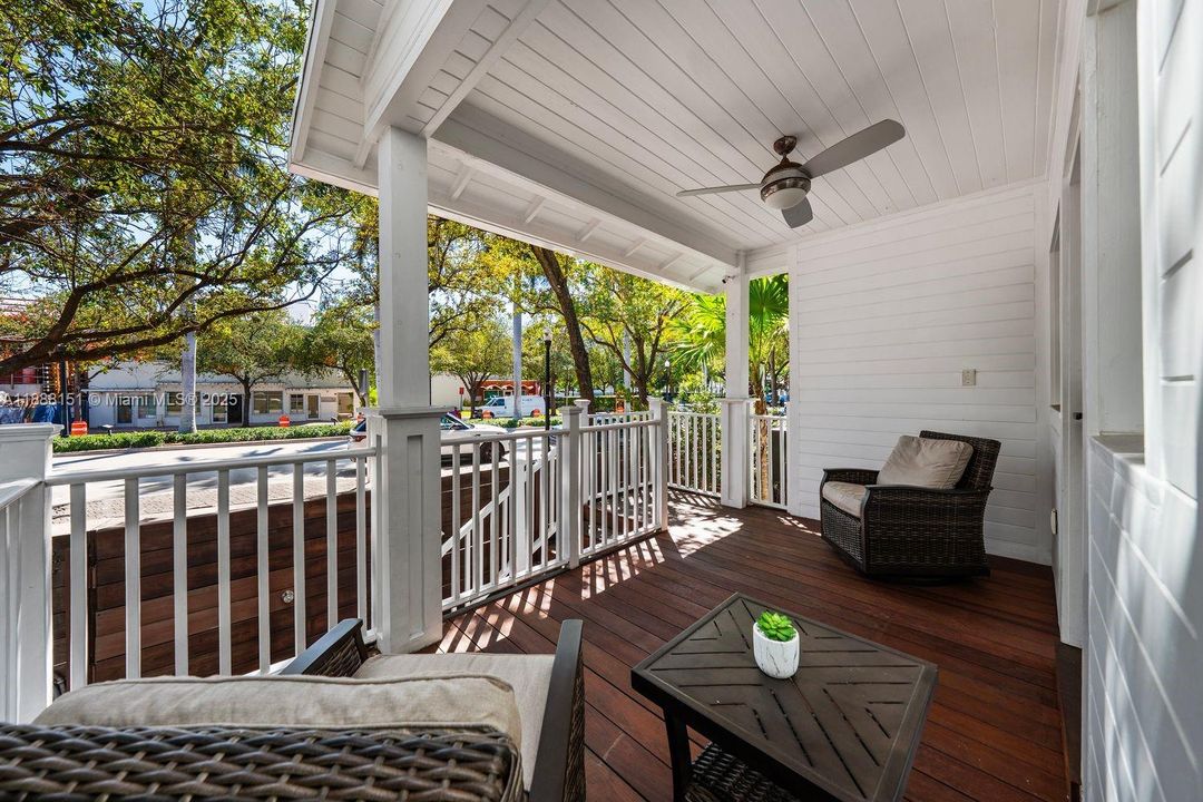 Covered outdoor patio with ceiling fan and wooden decking — great for al fresco dining or lounging year-round.