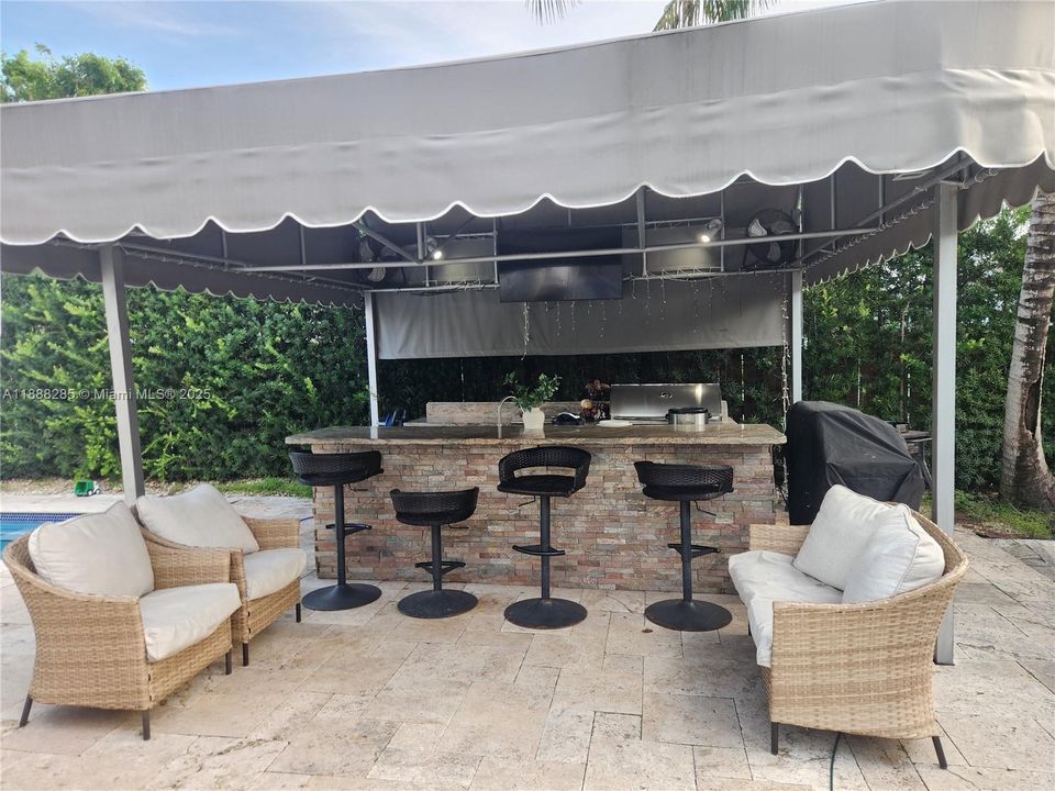 Outdoor kitchen with awning  a true luxury for year-round entertaining and enjoyment in the patio!